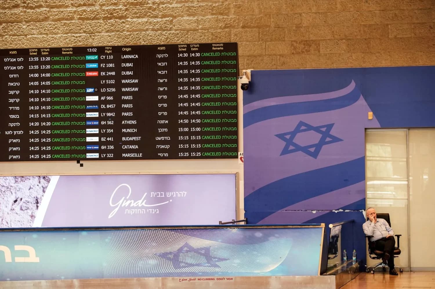 موظف في مطار بن غوريون الإسرائيلي يجلس في صالة الوصول في يونيو 2025 (رويترز)