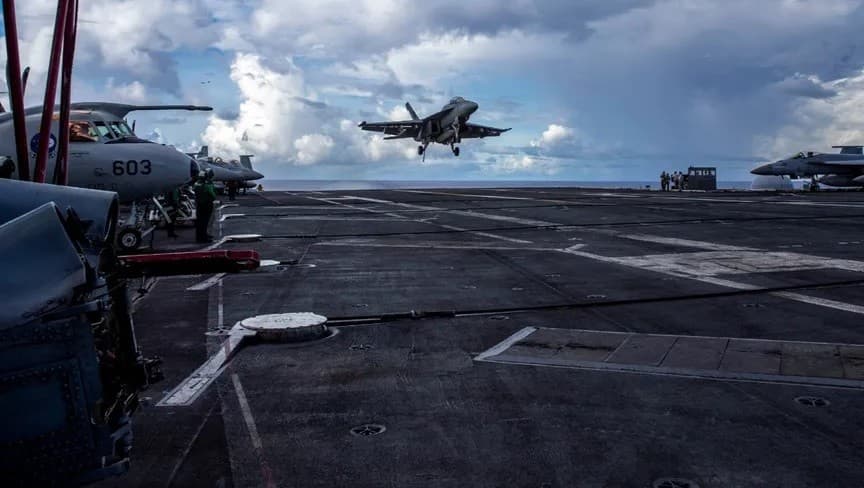 التدخل الأمريكي: طائرة مقاتلة من طراز F-18 تستعد للهبوط على سطح حاملة الطائرات الأميركية "يو إس إس أبراهام لينكولن" في المحيط الهادئ. 10 أغسطس 2024 - Reuters
