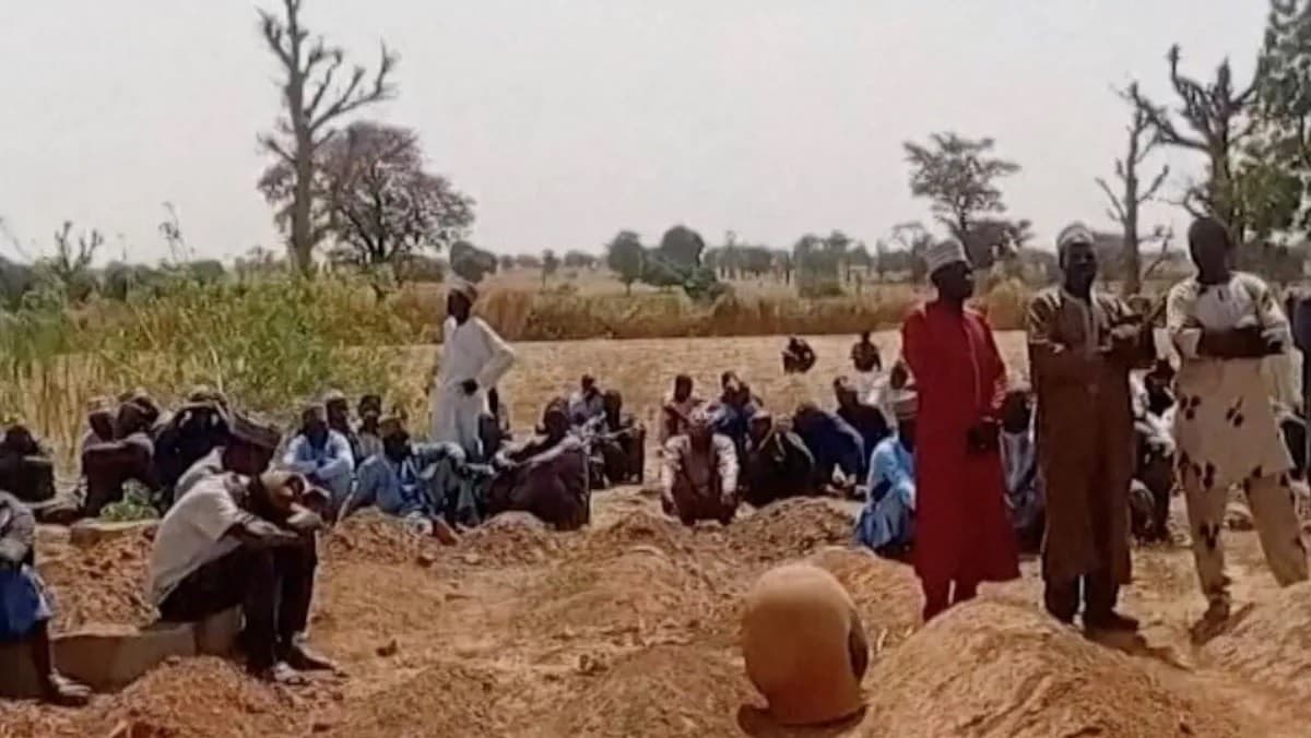 أشخاص يقفون حول قبور بعض ضحايا هجوم دموي شنته عصابة مسلحة في كاتسينا بنيجيريا. 4 فبراير 2026 - Reuters