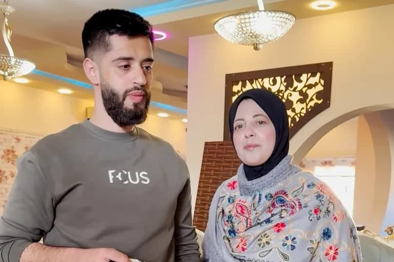 أم فلسطينية تسبق ابنها للاعتقال لتحميه من الاحتلال: سناء زكارنة ظهرت في مقطع فيديو ترافق ابنها عز الدين خلال اعتقاله في محاولة لحمايته (الجزيرة)