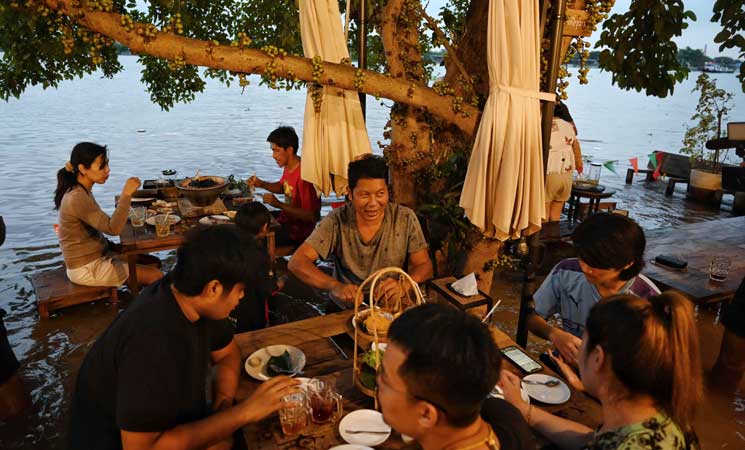 شاهد بالصور: مطعم تغمره مياه الفيضانات يجذب الزبائن في بانكوك
